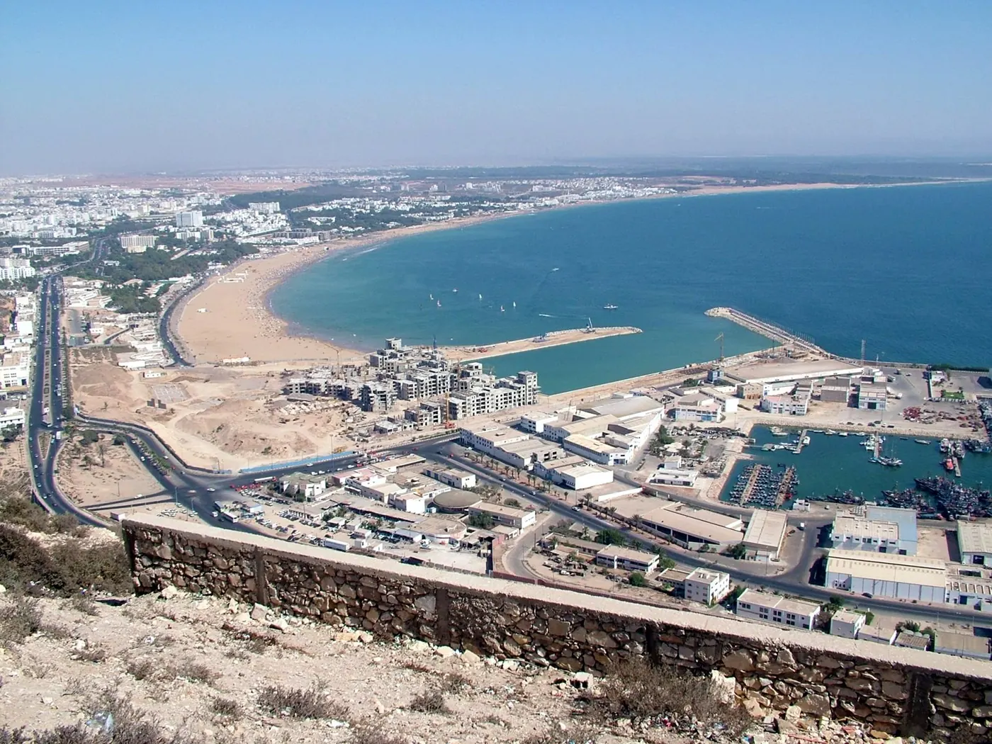 Elevated view of Agadir Bay, its broad sandy beach and the port