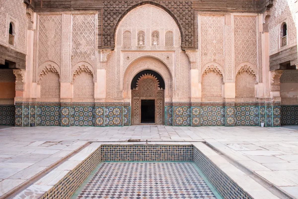 Wide view into Ben Youssef Madrasa’s courtyard, with the central basin and decorated galleries