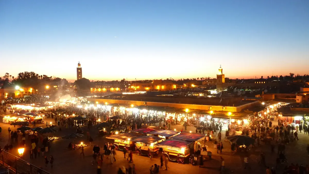 Crowds gather in Jemaa el-Fna square in Marrakech at dusk.