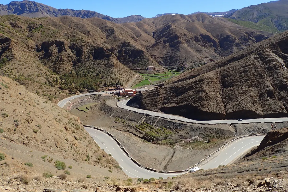 A section of Morocco’s N9 road near Tizi n’Tichka winding across a rocky Atlas mountain slope.