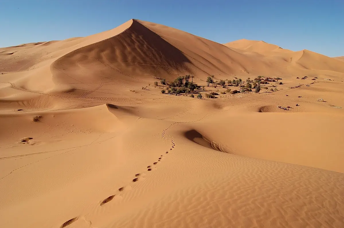 A settlement sits among the sand dunes of Erg Chebbi in Morocco.