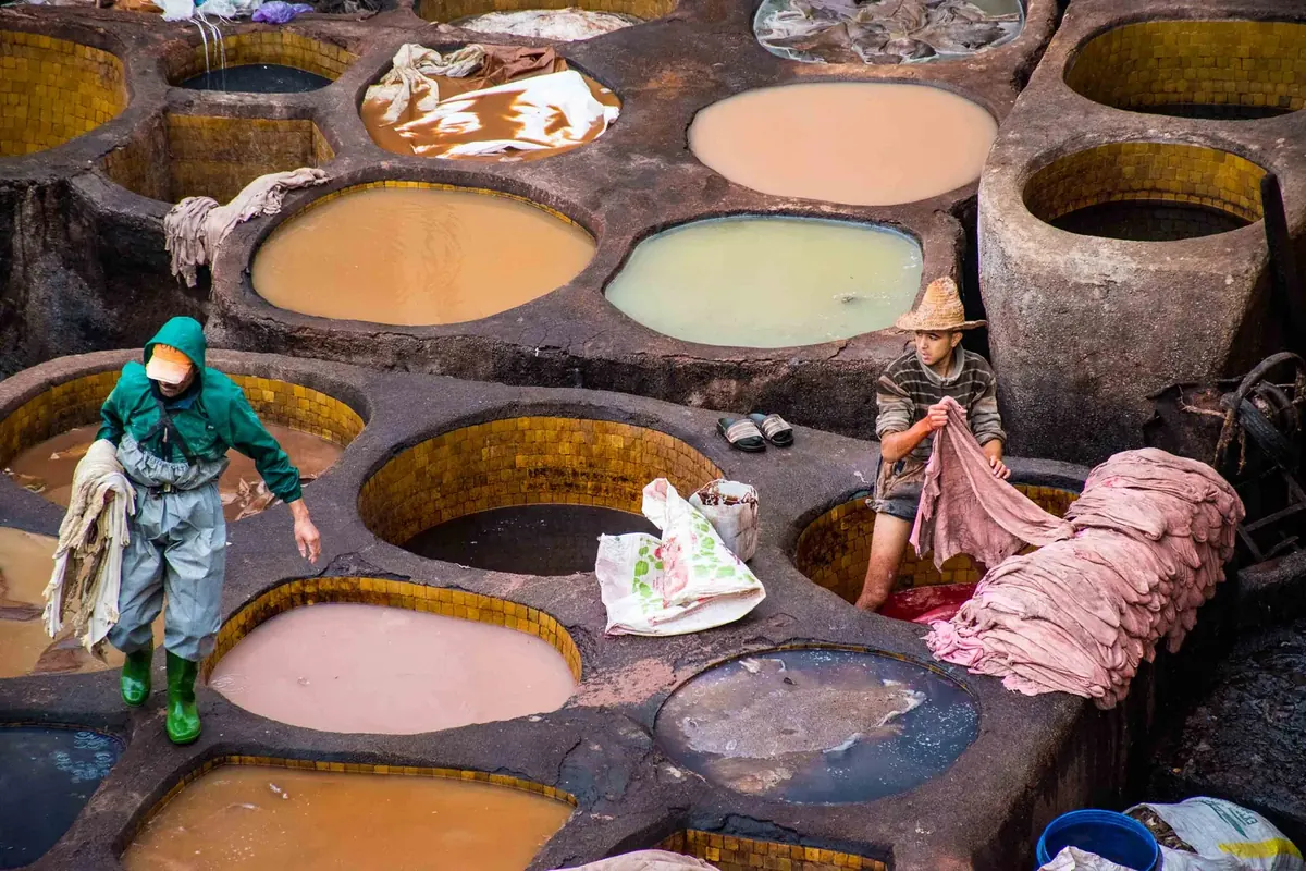 Workers dye leather in the Chouara tanneries in Fes el Bali, viewed from above.