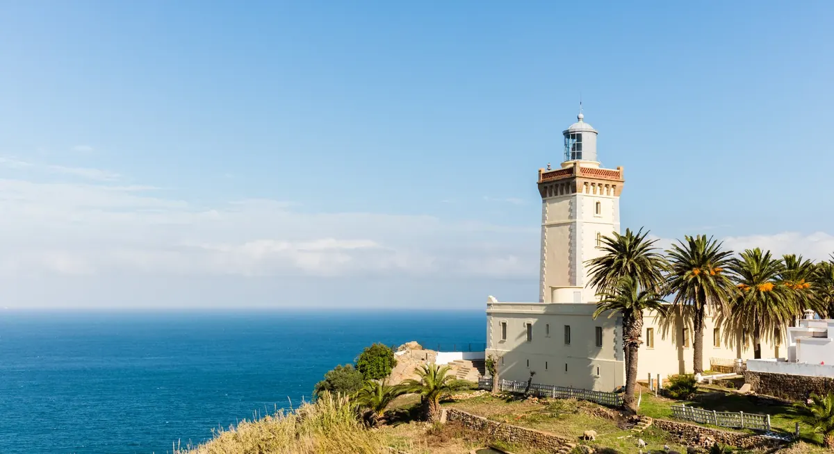 Cape Spartel lighthouse beside the Atlantic coast near Tangier, Morocco, beneath a clear sky.