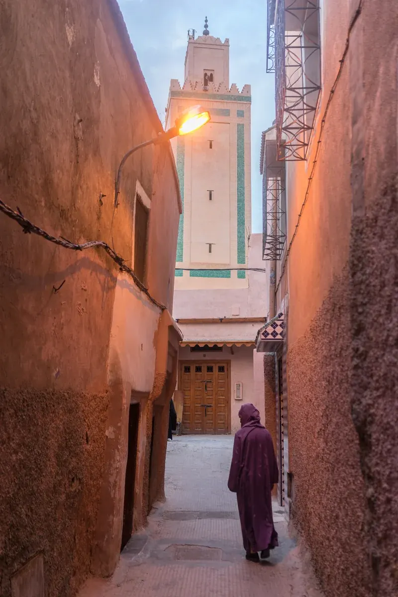 A woman in a djellaba walks down a narrow lane in Marrakech’s old medina.