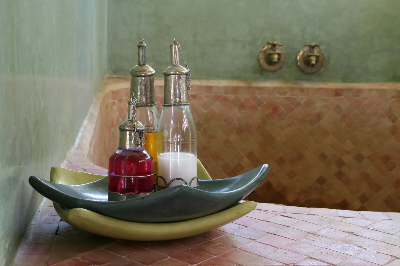 Oil bottles and tiled detail inside a Moroccan hammam in Marrakech