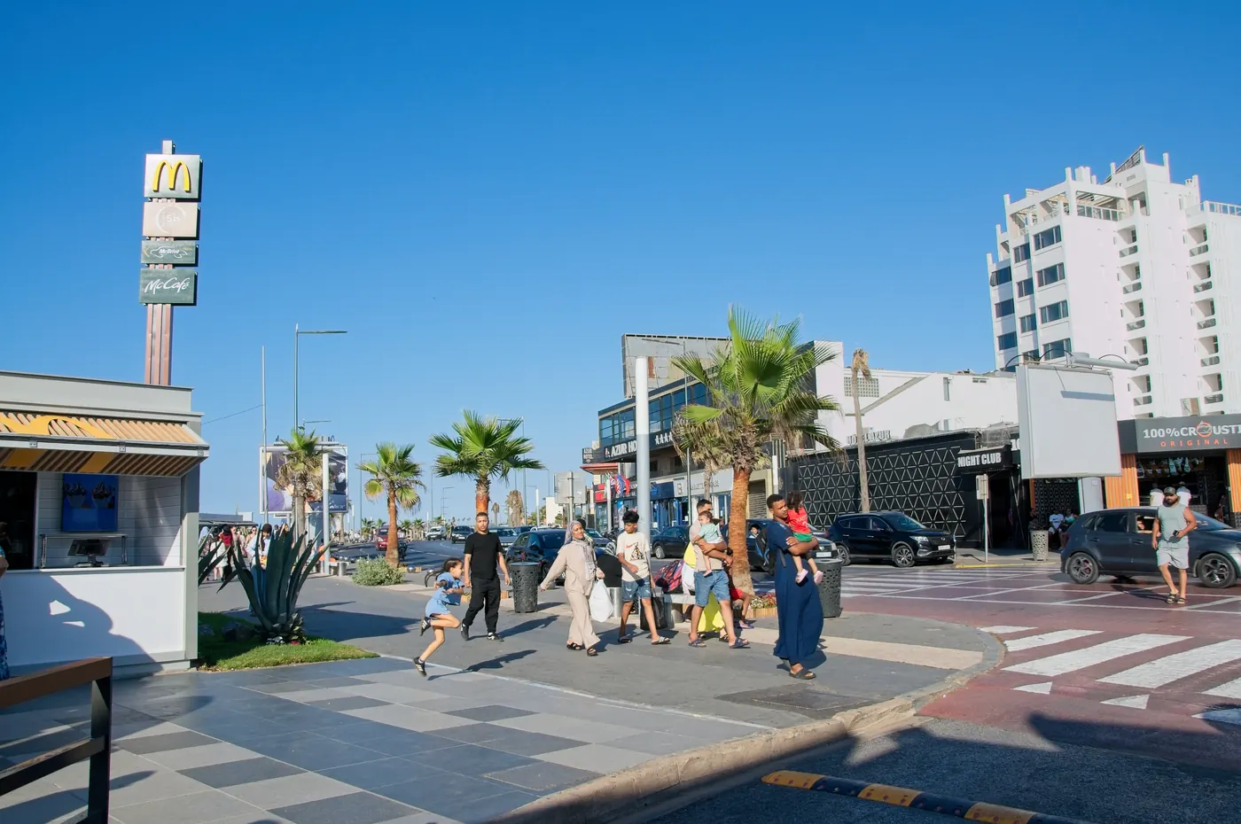 People walking beside restaurants on Boulevard de la Corniche in Ain Diab, Casablanca.