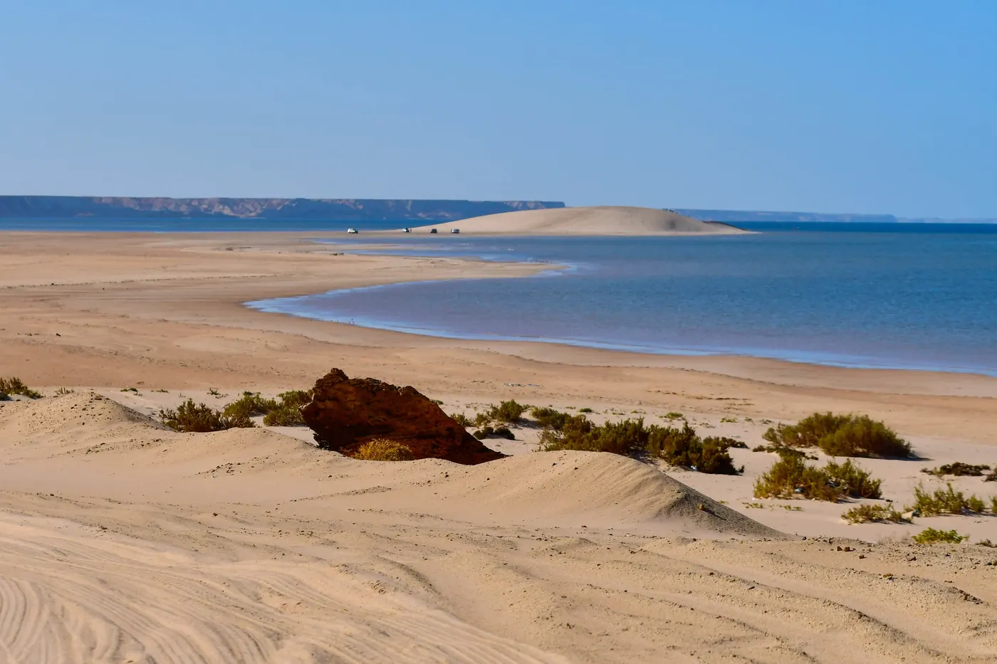 The White Dune beyond shallow water and sandy shore near Dakhla.