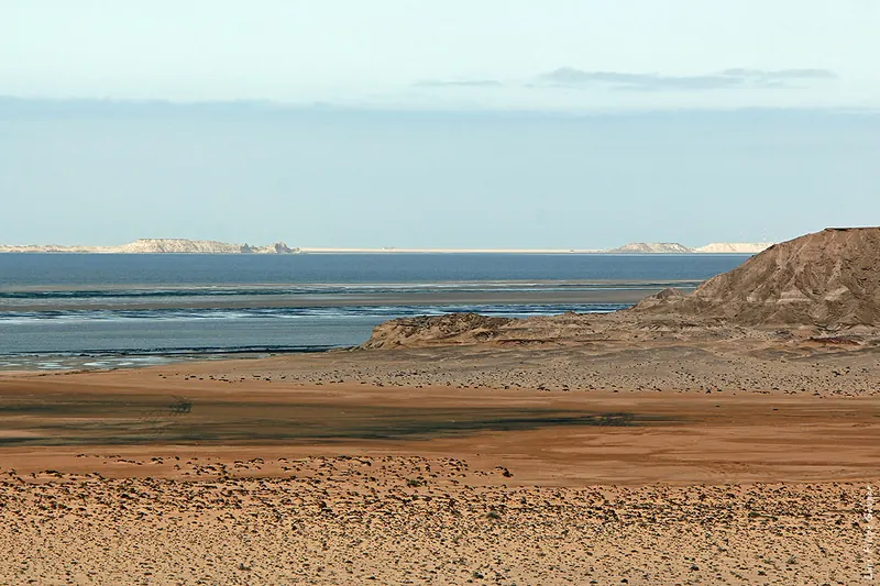 A wide view across sandy flats and water in Dakhla Bay.