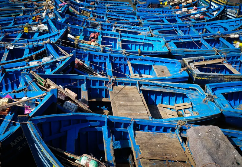 A close view of tightly moored blue fishing boats in Essaouira harbour