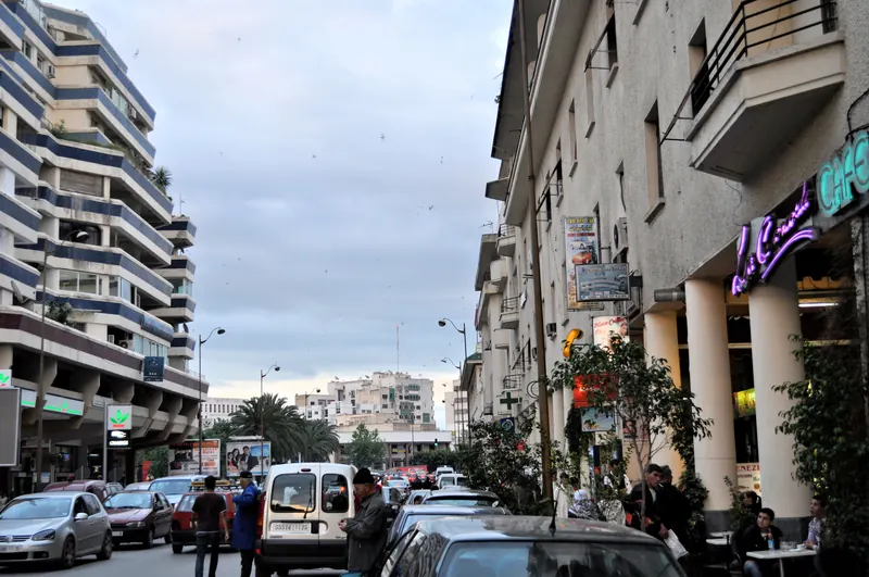 Street with cars, cafés and apartment buildings in Ville Nouvelle, Fez