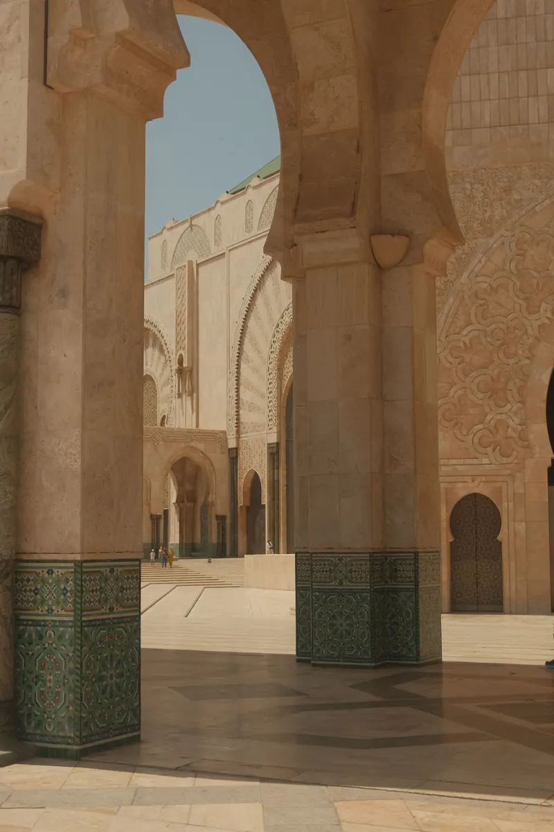 Arched courtyard detail with carved stone and green tilework at Hassan II Mosque in Casablanca.