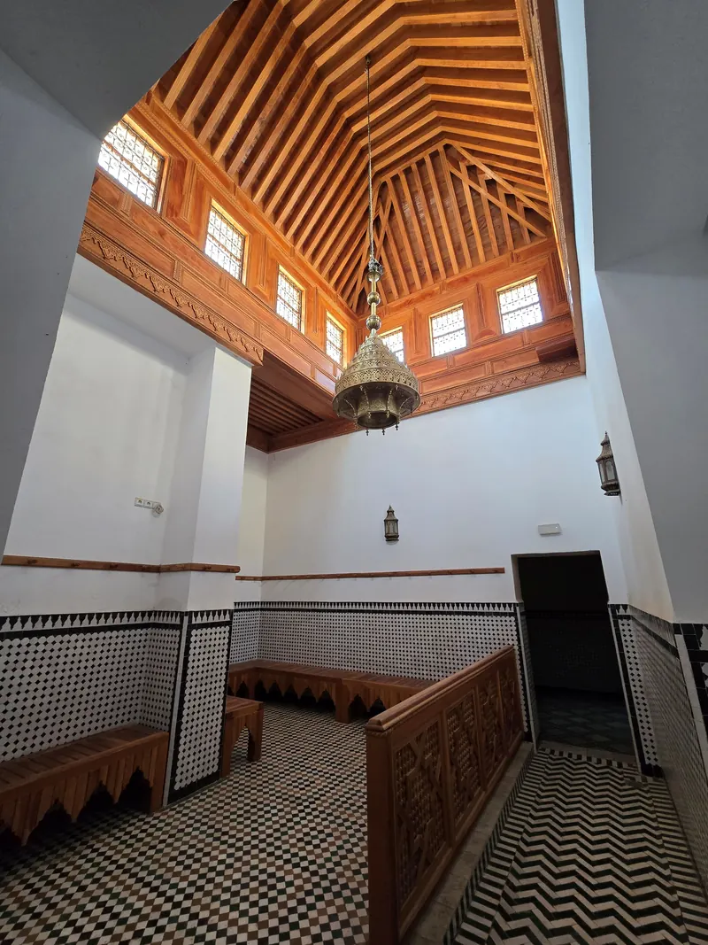 Empty women’s changing room with benches at Hammam Saffarin in Fes, Morocco