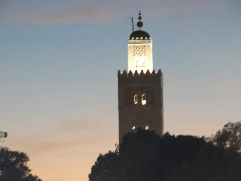 Koutoubia Minaret illuminated at dusk in Marrakech.