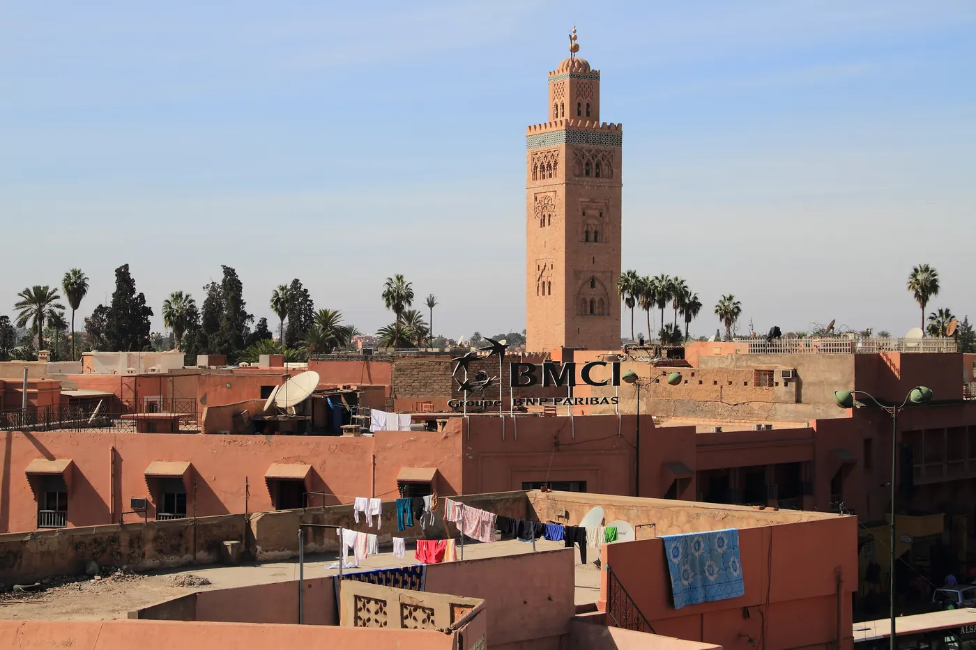 Koutoubia Minaret rising above low rooftops in Marrakech in daylight.