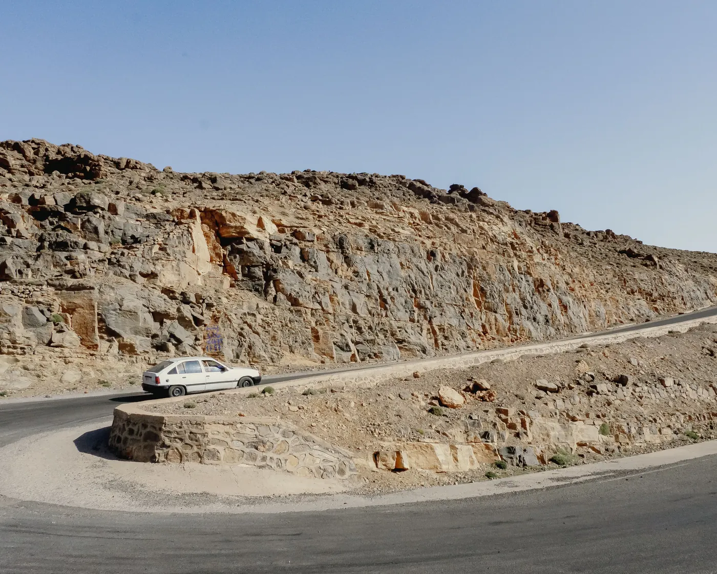 Car on a paved winding mountain road in Imilchil, Morocco’s Atlas Mountains