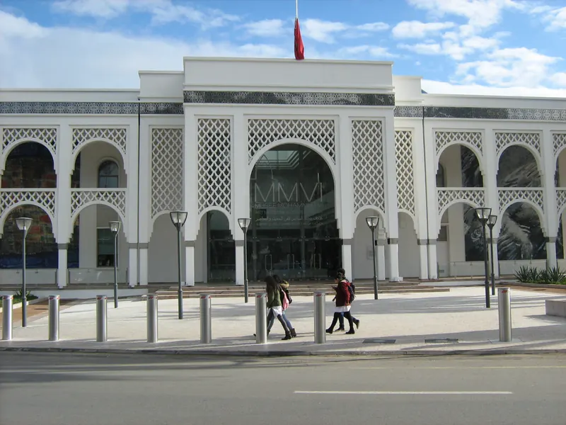 Front entrance façade of the Mohammed VI Museum of Modern and Contemporary Art in Rabat, with pedestrians on the pavement
