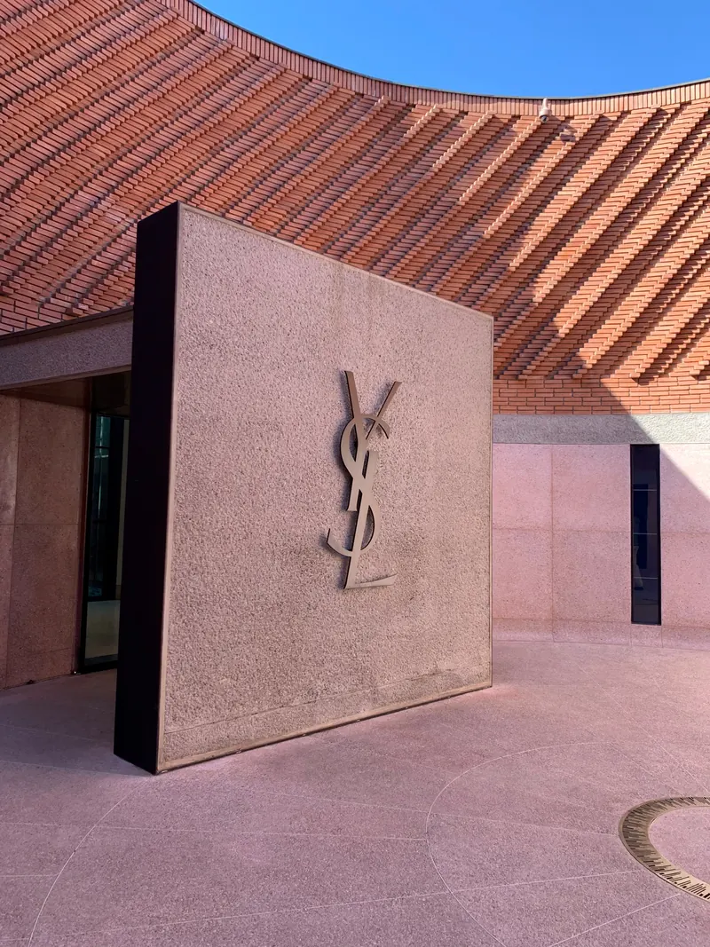 YSL logo on the entrance portal of the Musée Yves Saint Laurent Marrakech, against the patterned brick façade.