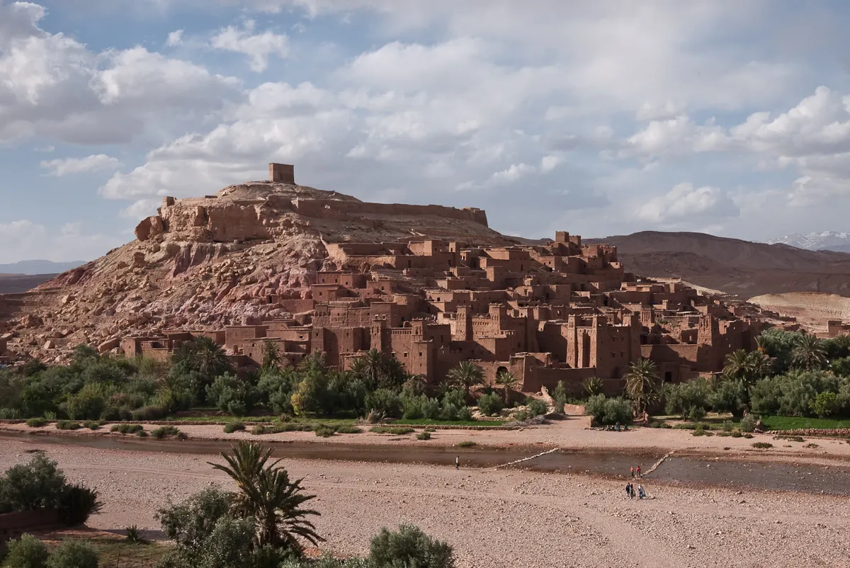 Aït Benhaddou’s earthen kasbah complex under an open blue sky in Morocco.