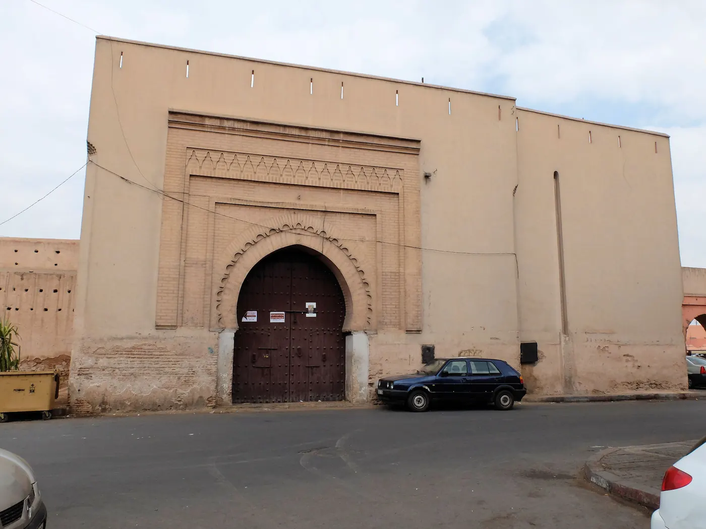 Exterior of Bab Doukkala, the northwestern gate of Marrakech's medina, with the road and rampart wall.
