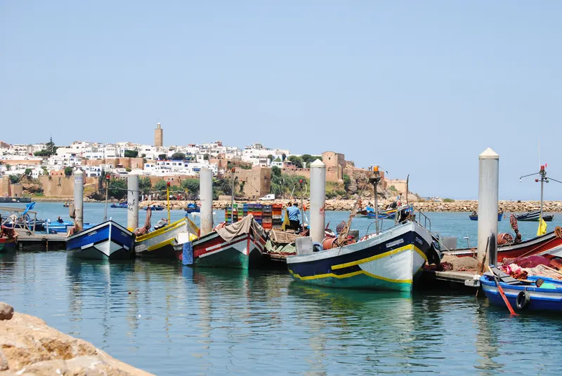 Fishing boats on the Bouregreg River with the Kasbah of the Udayas in Rabat beyond.