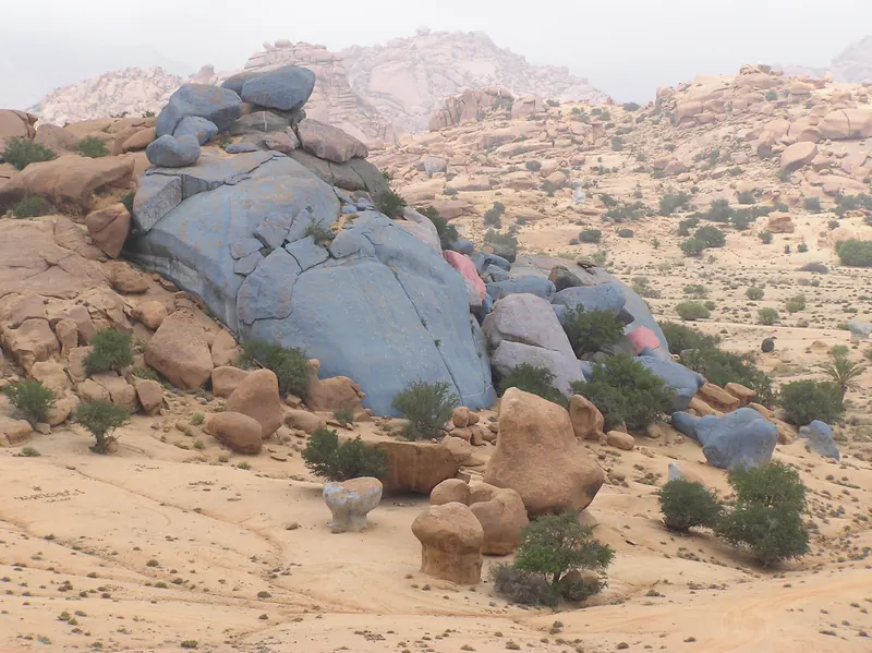 Blue-painted boulders among unpainted granite rocks near Tafraoute
