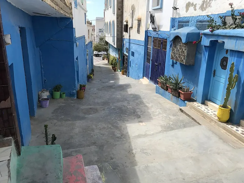 A narrow blue-painted residential lane in Taghazout, Morocco.