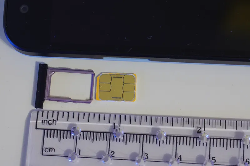 A nano-SIM card beside the tray for a Nexus 5X smartphone, shown with a ruler for scale