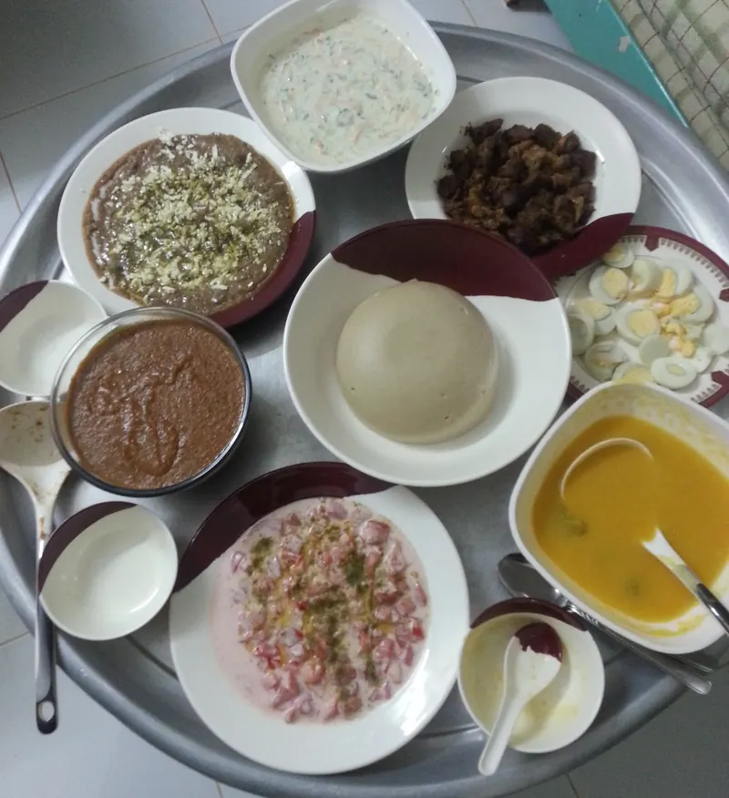 A tray holding bowls and plates of food for an iftar meal
